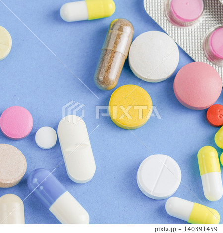 Macro close up of assorted pharmaceutical pills and capsules next to blister pack 140391459