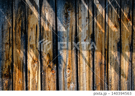 Rustic weathered wood fence texture sunlight and shadow play natural timber background for outdoor design and vintage concepts. 140394563