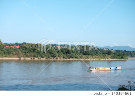 Beautiful Traditional boat  in Mekong river forms the border between Thailand and Laos with blue sky. 140394661