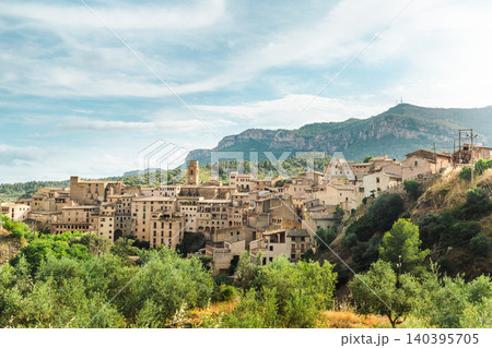 Panoramic view of Cornudella de Montsant village surrounded by olive groves and Montsant mountains in Catalonia Spain, traditional stone architecture Panoramic view of Cornudella de Montsant village surrounded by olive groves and Montsant mountains in Catalonia Spain, traditional stone architecture 140395705