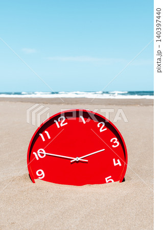 a red clock on a broad deserted beach a red clock on a broad deserted beach 140397440