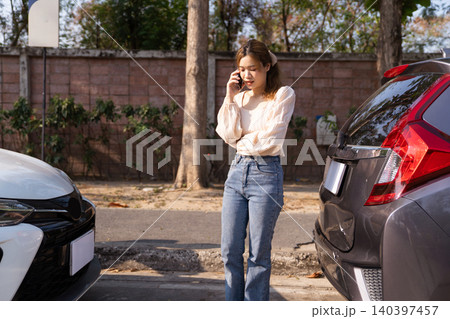 Woman calls insurance after two cars collide on road Woman calls insurance after two cars collide on road 140397457
