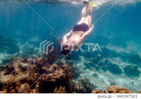 Man Snorkeling with Yellow Flippers in Coral Reef Turquoise Sea Man Snorkeling with Yellow Flippers in Coral Reef Turquoise Sea 140397501