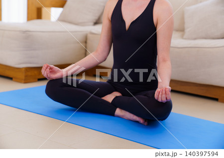 Young woman in meditation pose on blue yoga mat Young woman in meditation pose on blue yoga mat 140397594