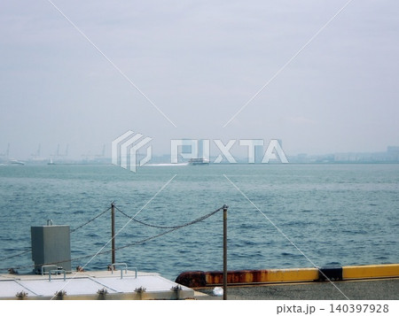 港の岸壁から望む海と遠くに霞むビル群 港の岸壁から望む海と遠くに霞むビル群 140397928