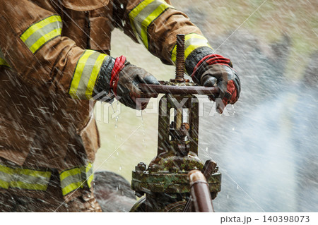 Firefighter Hands Turning Water Valve in Action Firefighter Hands Turning Water Valve in Action 140398073