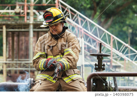 Firefighter adjusting gloves during emergency training session Firefighter adjusting gloves during emergency training session 140398075