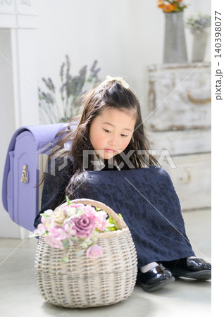 ランドセルを背負って花の入ったカゴを眺める日本人の女の子 ランドセルを背負って花の入ったカゴを眺める日本人の女の子 140398077