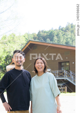 ペンション前に立つ笑顔の夫婦オーナー 140398082