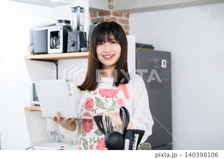 キッチンでノートパソコンを持つ日本人女性 キッチンでノートパソコンを持つ日本人女性 140398106