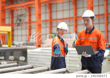 Industrial engineers inspecting machinery layout in a factory Industrial engineers inspecting machinery layout in a factory 140398471
