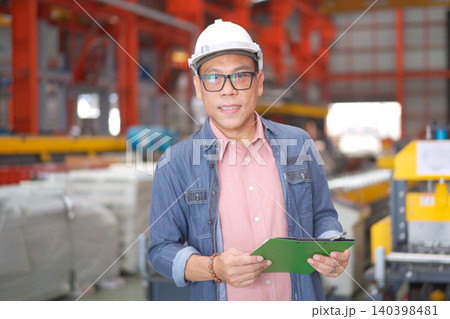 Portrait of a confident Asian factory manager holding a clipboard Portrait of a confident Asian factory manager holding a clipboard 140398481