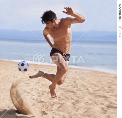 Male athlete, soccer and sand on beach, exercise and training for cardio sports. Bathing suit, football and athletic man on holiday and fun on shoreline, summer and workout and outdoor on vacation 140400229