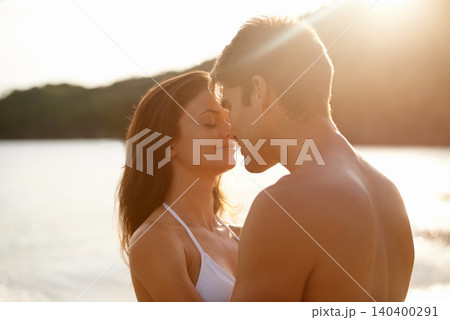 Love, kiss and couple on island for date on romantic anniversary vacation, adventure or holiday. Smile, bonding and young man and woman embracing with care by ocean at sunset on weekend trip together Love, kiss and couple on island for date on romantic anniversary vacation, adventure or holiday. Smile, bonding and young man and woman embracing with care by ocean at sunset on weekend trip together 140400291