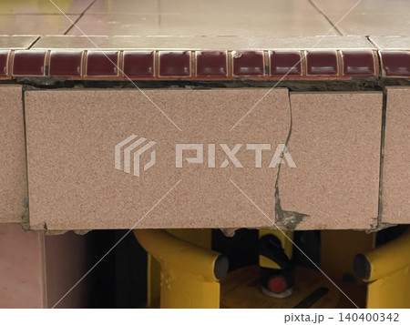 Close Up Of Cracked Pink Ceramic Tile With Messy DIY Repair Fix Close Up Of Cracked Pink Ceramic Tile With Messy DIY Repair Fix 140400342