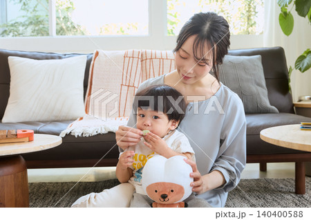 リビングで子供を抱っこして口ポカンの癖をなおす母親 リビングで子供を抱っこして口ポカンの癖をなおす母親 140400588
