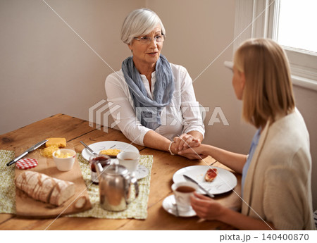 Senior mom, daughter and home with conversation in table for bonding, support and visit. Holding hands, family and meal with tea, food and chat on breakfast together with care, smile and love Senior mom, daughter and home with conversation in table for bonding, support and visit. Holding hands, family and meal with tea, food and chat on breakfast together with care, smile and love 140400870