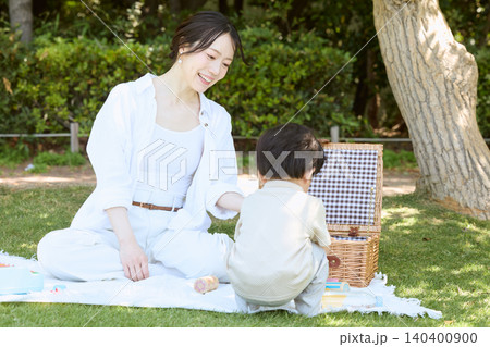 公園でピクニックを楽しむ母親と赤ちゃん 公園でピクニックを楽しむ母親と赤ちゃん 140400900