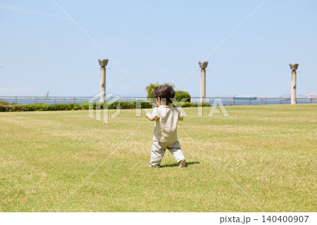 芝生の公園をよちよち歩きする幼児の後ろ姿 芝生の公園をよちよち歩きする幼児の後ろ姿 140400907