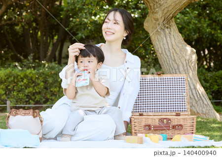 公園でピクニックを楽しむ母親と赤ちゃん 公園でピクニックを楽しむ母親と赤ちゃん 140400940