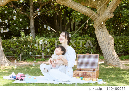 公園でシャボン玉を見上げる母親と赤ちゃんのピクニック 公園でシャボン玉を見上げる母親と赤ちゃんのピクニック 140400953