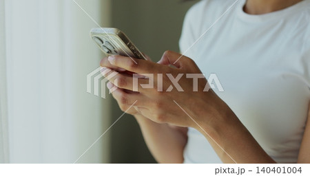 Hand of girl using smartphone in the living room at home, typing message. Close-up of young women hand. Hand of girl using smartphone in the living room at home, typing message. Close-up of young women hand. 140401004
