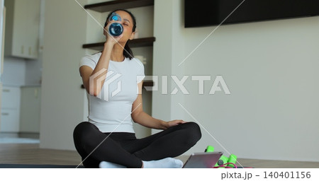 Online video tutorial while virtual training at home. Workout at home in living room, viewing online training on tablet. 140401156