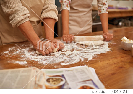 Dough, recipe and hands of people on table, baking in kitchen and closeup on process in bakery. Person, prepare and press bread with flour, meal prep and working with information or guide from book 140401233