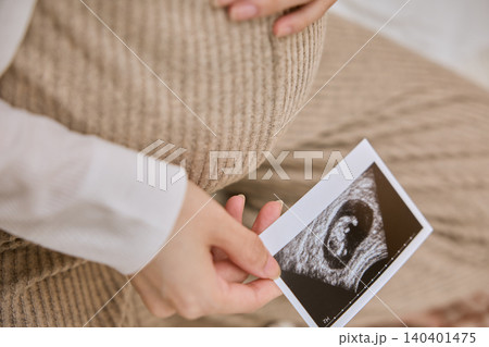 エコー写真を持ちお腹に手を当てる妊婦 エコー写真を持ちお腹に手を当てる妊婦 140401475