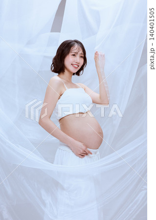 白い布に包まれた妊婦の女性 穏やかなマタニティのイメージ 白い布に包まれた妊婦の女性 穏やかなマタニティのイメージ 140401505