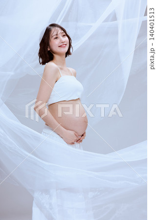 白い布に包まれた妊婦の女性 穏やかなマタニティのイメージ 白い布に包まれた妊婦の女性 穏やかなマタニティのイメージ 140401513