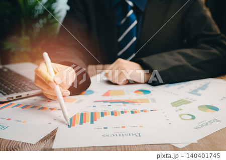 Business Man Analyzing Charts and Graphs with Laptop on Desk in Modern Office Setting, Business concept Business Man Analyzing Charts and Graphs with Laptop on Desk in Modern Office Setting, Business concept 140401745