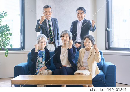 ソファで拳を上げて笑顔を見せるシニアビジネスチーム ソファで拳を上げて笑顔を見せるシニアビジネスチーム 140401841