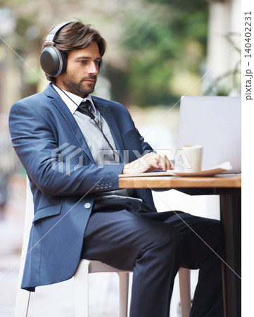 Businessman, laptop and headphone working in cafe, internet and social media for online meeting and remote work. Professional, technology and lunch break with coffee and google it for networking idea 140402231