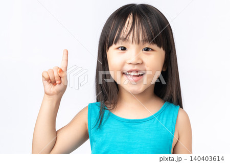 Happy Asian girl pointing finger up having a great idea, eureka moment or discovery concept. Happy Asian girl pointing finger up having a great idea, eureka moment or discovery concept. 140403614