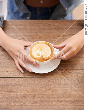 Person hands, coffee cup and foam in cafe espresso, caffeine and latte art on wooden table. Cappuccino mug, hot milk and cream for taste with drink, fresh and warm beverage in restaurant for break 140403773