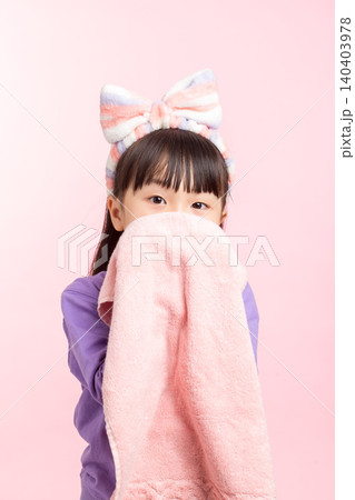 A close-up shot of an Asian girl wiping her face with a towel. A close-up shot of an Asian girl wiping her face with a towel. 140403978