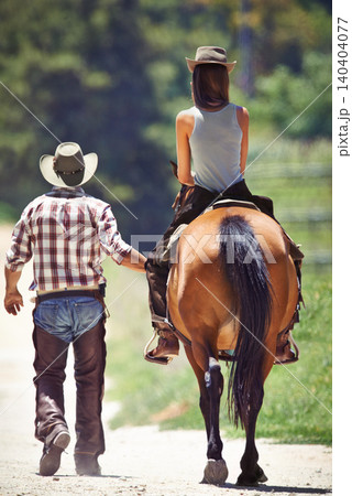 Back of woman, cowboy or horse riding on countryside farm as equestrian for training, sport or learning. Walking, teaching or people in Texas, outdoor environment or stable for practice on saddle 140404077