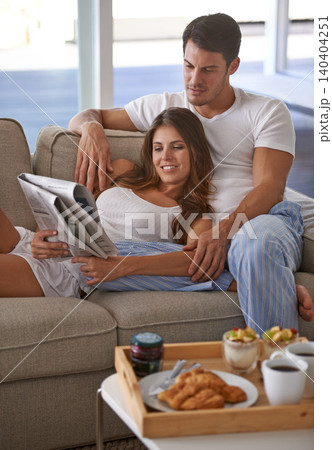 Love, couple and touch for relax, newspaper and reading for bonding together on sofa at home. Boyfriend, girlfriend and breakfast for happy, relationship and global news with rest and relaxation Love, couple and touch for relax, newspaper and reading for bonding together on sofa at home. Boyfriend, girlfriend and breakfast for happy, relationship and global news with rest and relaxation 140404251