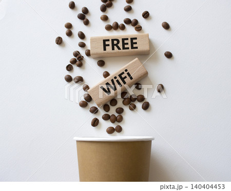 Fee Wifi symbol. Concept words Fee Wifi on beautiful wooden picture frame. Beautiful white background with coffee cup and coffee beans. Business and Fee Wifi concept. Copy space. Fee Wifi symbol. Concept words Fee Wifi on beautiful wooden picture frame. Beautiful white background with coffee cup and coffee beans. Business and Fee Wifi concept. Copy space. 140404453