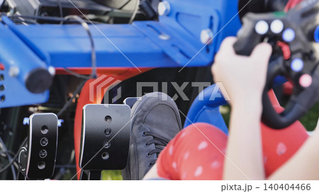 Gamer playing racing video game simulation using steering wheel and pedals 140404466