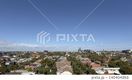 A sunny autumn day over a typical Australian residential neighborhood in Melbourne. Panoramic view of suburban homes, green trees, and the distant metropolitan horizon under a clear sky. A sunny autumn day over a typical Australian residential neighborhood in Melbourne. Panoramic view of suburban homes, green trees, and the distant metropolitan horizon under a clear sky. 140404868
