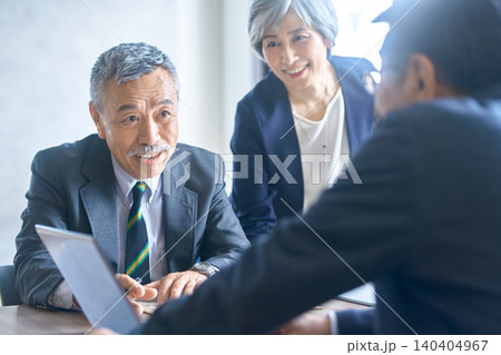 会議で書類を手に説明するシニア男性ビジネスマン 140404967