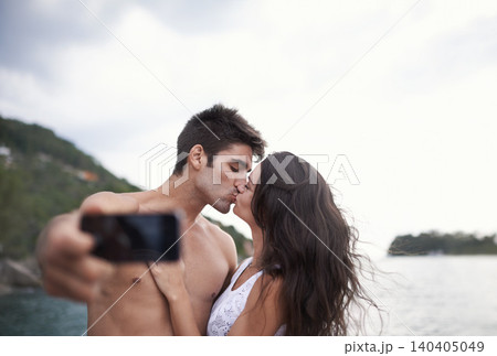 Kiss, selfie and couple at ocean for vacation, holiday or travel together outdoor. Photography, woman and man at sea for love, adventure and taking pictures for memory in summer by water in nature Kiss, selfie and couple at ocean for vacation, holiday or travel together outdoor. Photography, woman and man at sea for love, adventure and taking pictures for memory in summer by water in nature 140405049