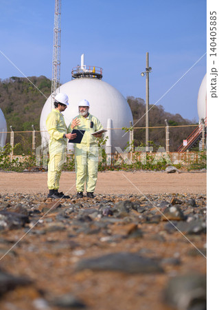 Two engineers in yellow suits stand outdoors Two engineers in yellow suits stand outdoors 140405885