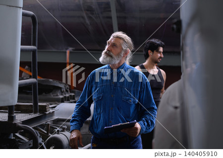 Senior mechanic inspects heavy vehicle systems Senior mechanic inspects heavy vehicle systems 140405910