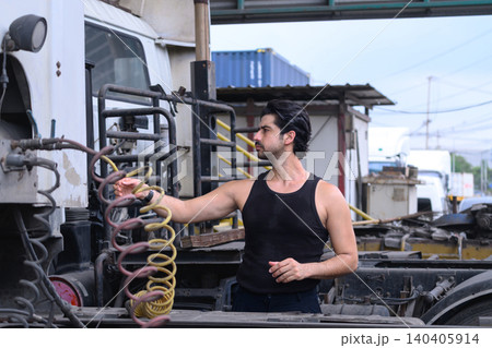 Worker inspects truck coupling with focused attention Worker inspects truck coupling with focused attention 140405914