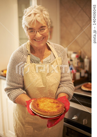 Elderly lady, pie and smiling in kitchen at home for baking, cooking or retirement leisure. Happy, and proud senior person or grandmother with glasses for food recipes, meals and hobby in house Elderly lady, pie and smiling in kitchen at home for baking, cooking or retirement leisure. Happy, and proud senior person or grandmother with glasses for food recipes, meals and hobby in house 140406048