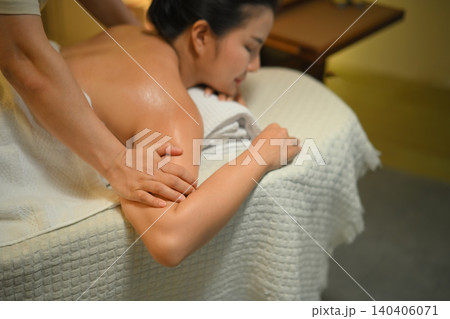 Closeup woman receiving spa massage with therapist in warm calm wellness room Closeup woman receiving spa massage with therapist in warm calm wellness room 140406071