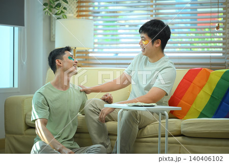 LGBTQ partners sharing skincare routine together applying eye mask LGBTQ partners sharing skincare routine together applying eye mask 140406102